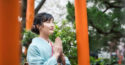 神社で祈る女性