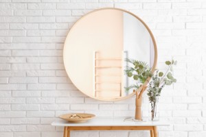 Big,Round,Mirror,,Table,With,Jewelry,And,Decor,Near,Brick