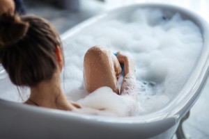 浴槽で足を洗う女性